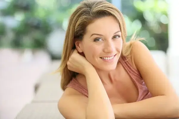 Attraktive lächelnde reife Frau, die sich zu Hause entspannt - symbolisiert natürliche Schönheit, Charme und echte Verbundenheit im Oma Sextreffen.